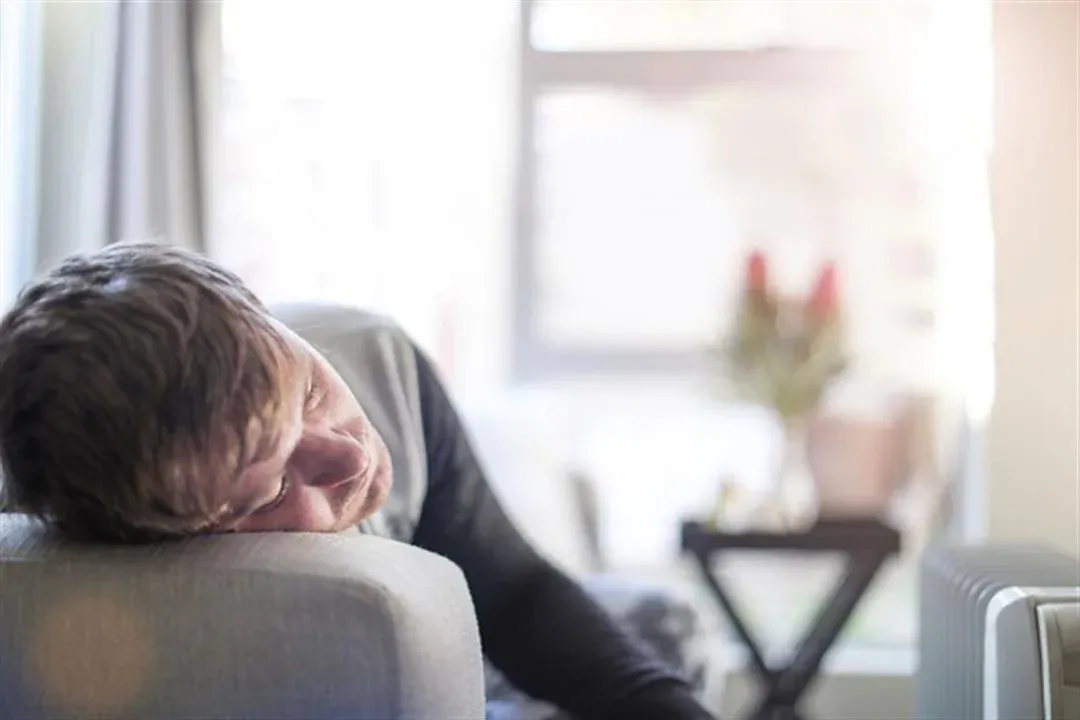 Tired man resting his head on the arm of a chair