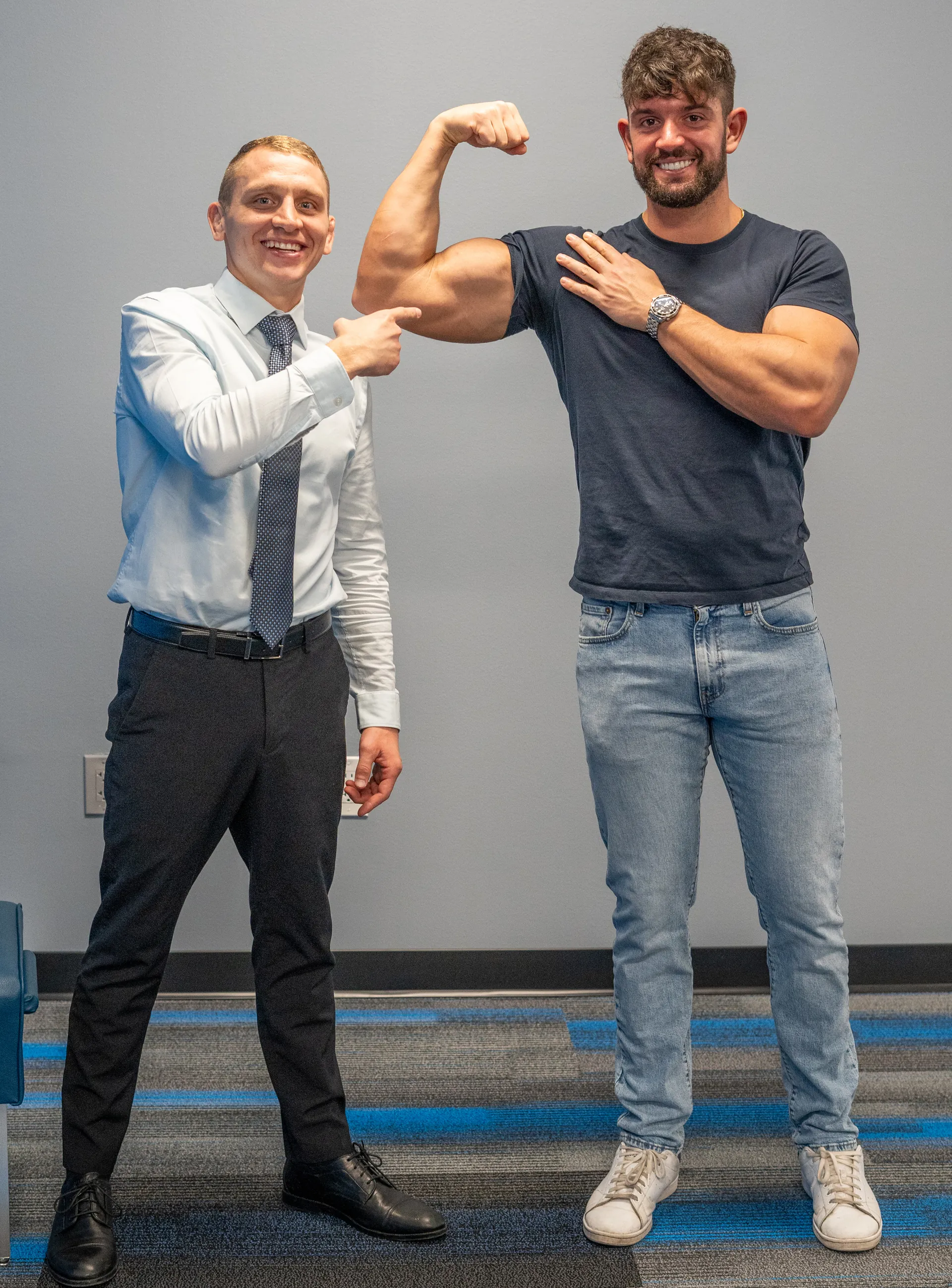 Patient flexing his arm while Dr. Jacoby Bergeron points at it in the clinic
